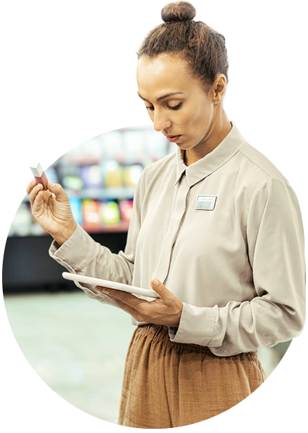 mulher com batom na mão, olhando para um tablet, representando controle de estoque
