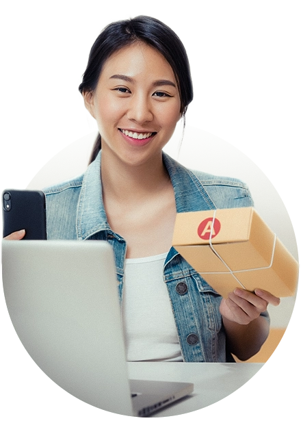 mulher com caixa e celular nas mãos, e notebook na mesa, representando integrações da loja virtual para melhorar as vendas