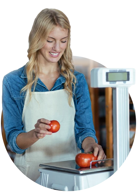 mulher pesando tomates em balança para representar a integração do sistema com balança